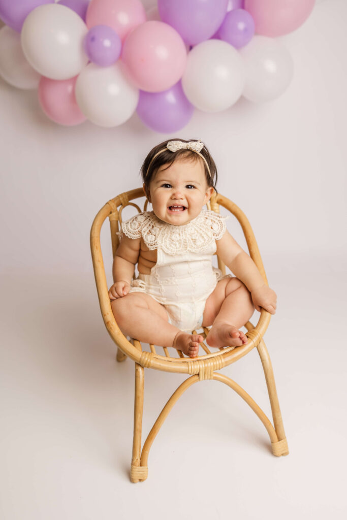 12 Month old baby girl wearing a cream lace romper during her one year celebration session with Molly Berry Photography