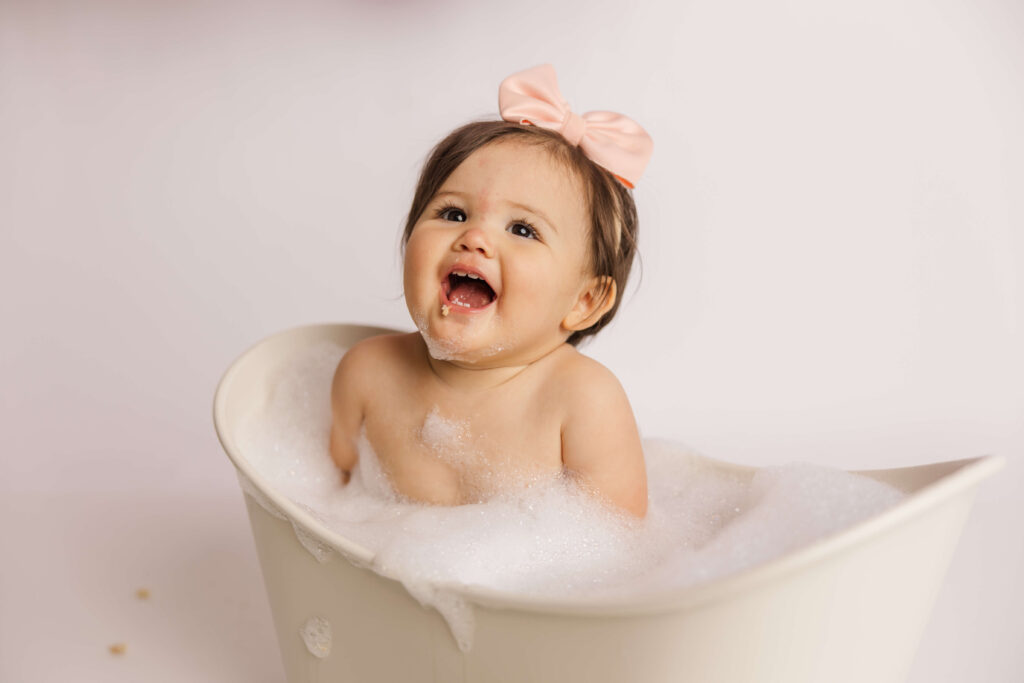 One year old enjoying her bubble bath during her recent one year old cake smash session.
