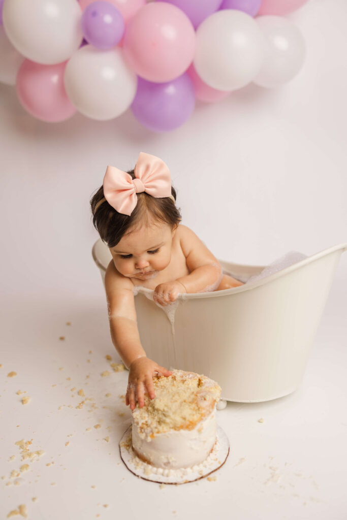 One year old enjoying her bubble bath at the end of her cake smash session with Molly Berry Photography