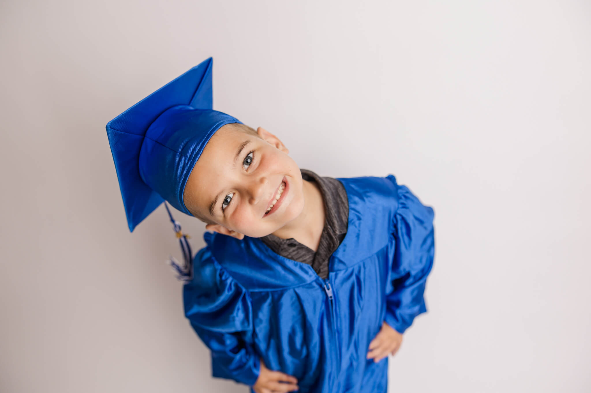 Four year old celebrating his preschool completion with a cap and gown session in the studio. Highly-Rated Augusta Preschools