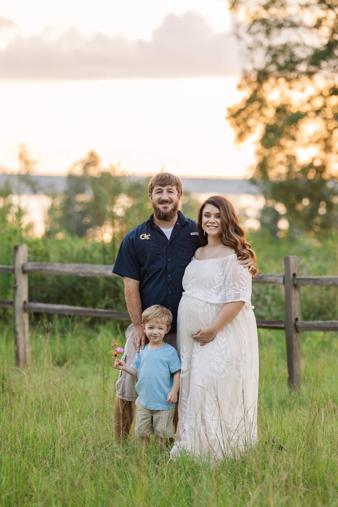 Family of three capturing a moment together during their family maternity session at Clarks Hill Lake
