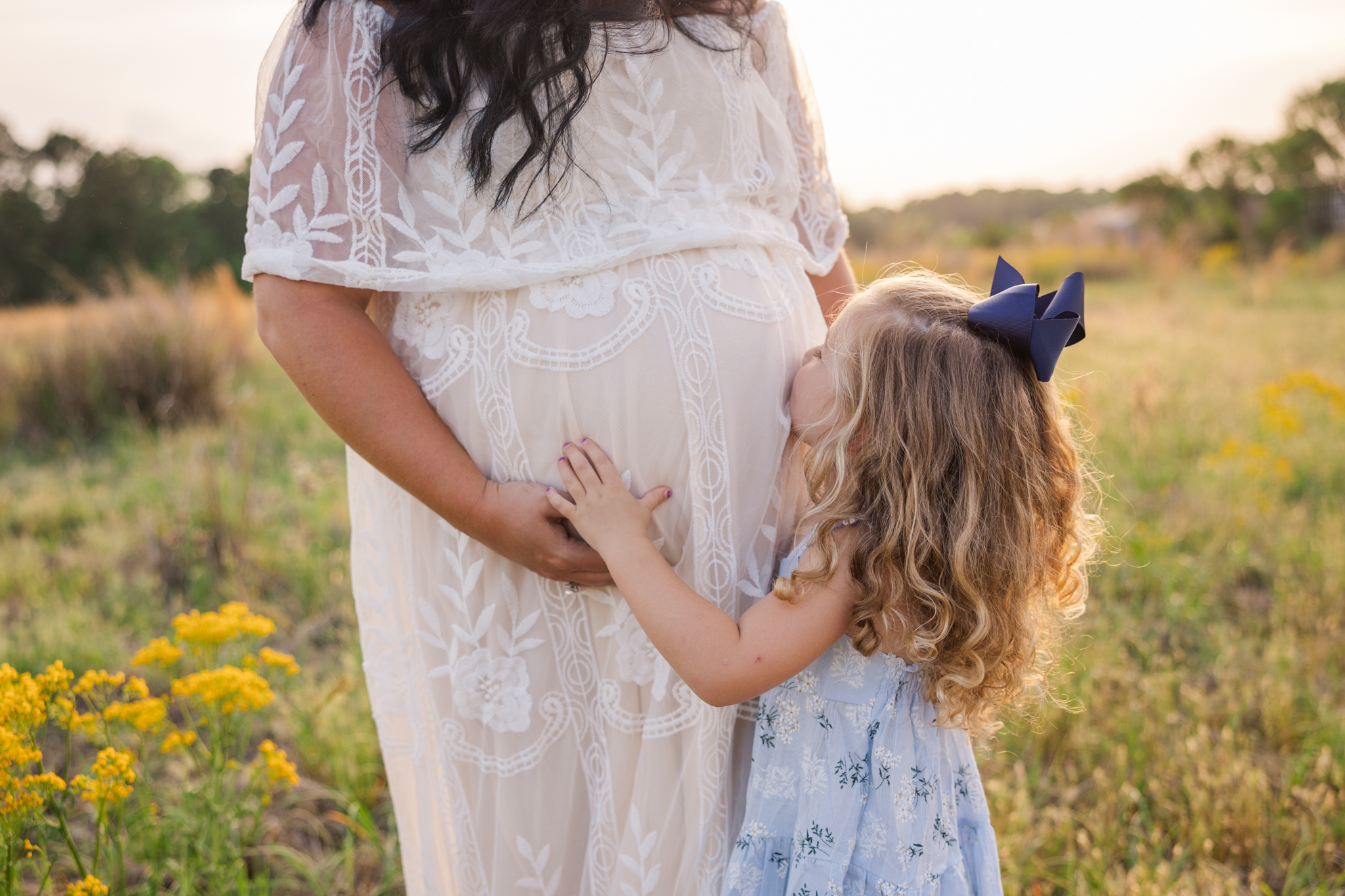 Expecting mom and daughter capturing a sweet moment during their maternity session.