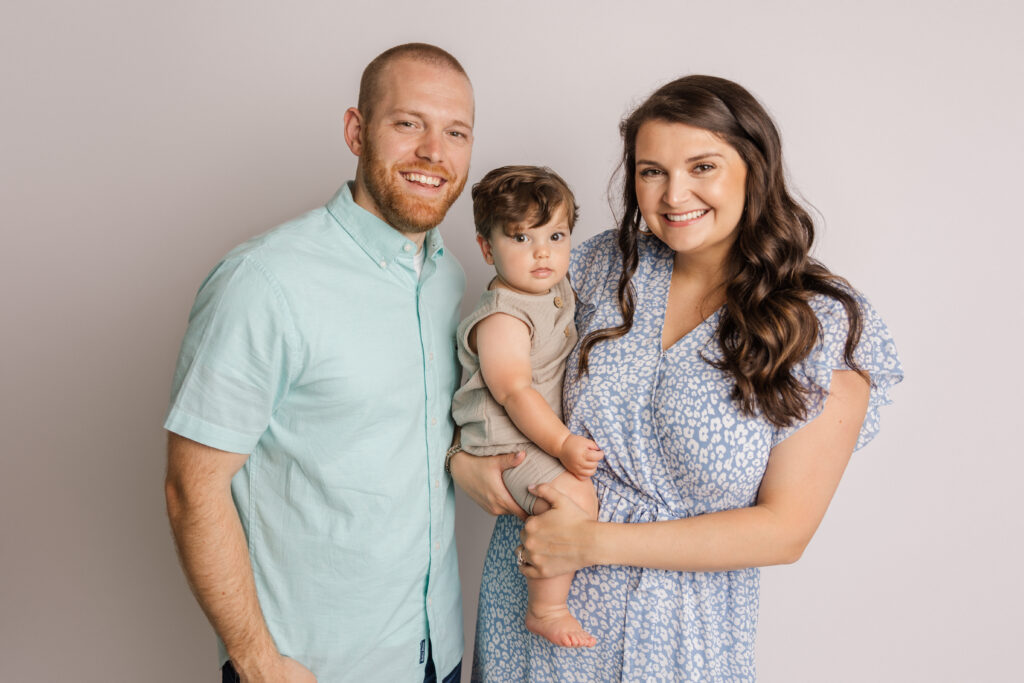 Family portrait of family of three that is celebrating sweet boy's first birthday.