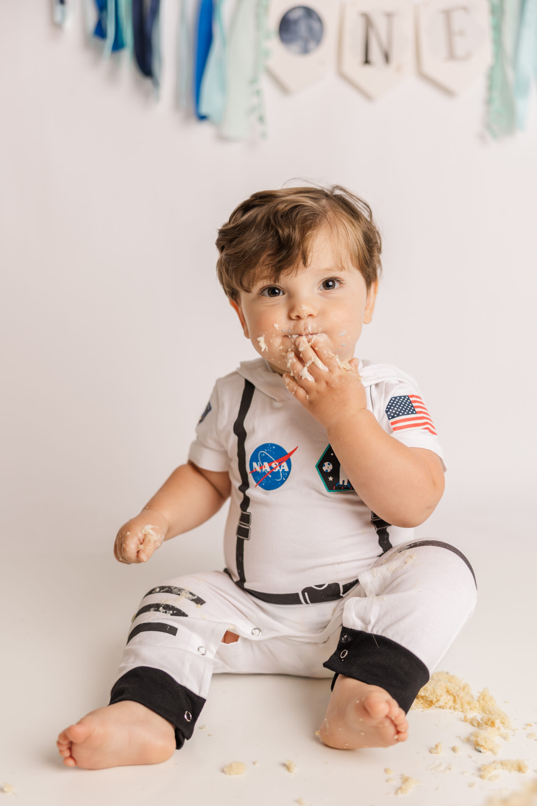 One year old enjoying his vanilla cake during his Space themed cake smash session. 
