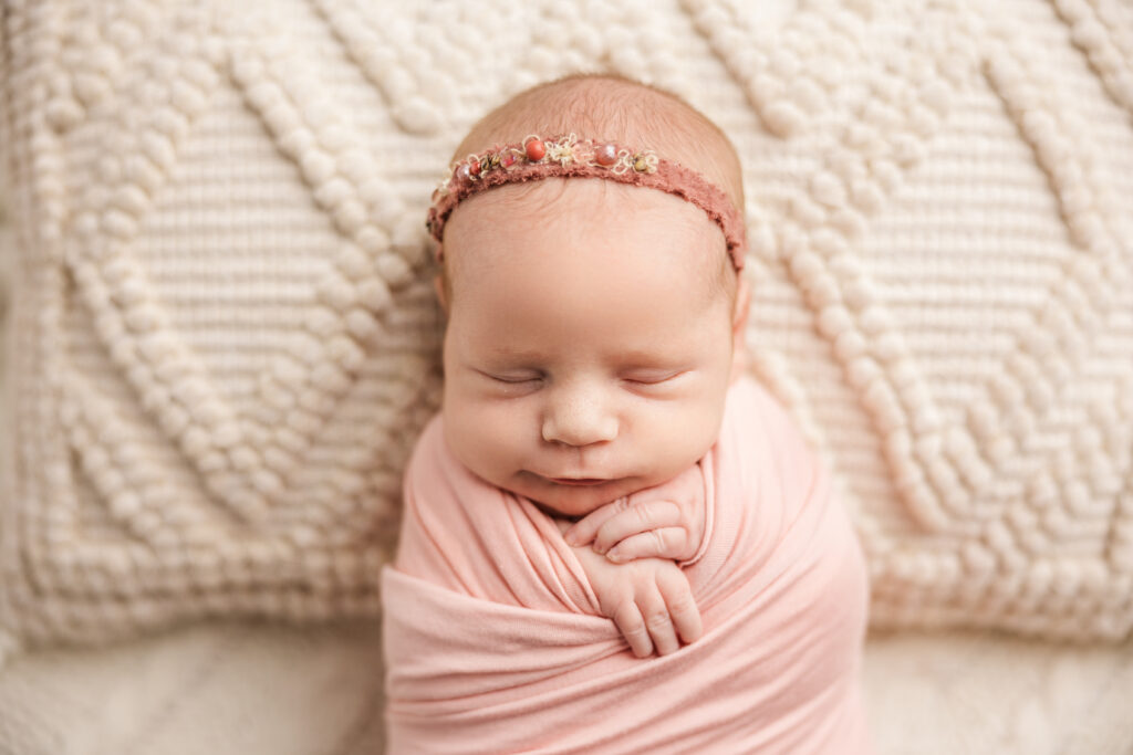 Sweet baby girl showing off her cheeks during her newborn session in the studio by Molly Berry

