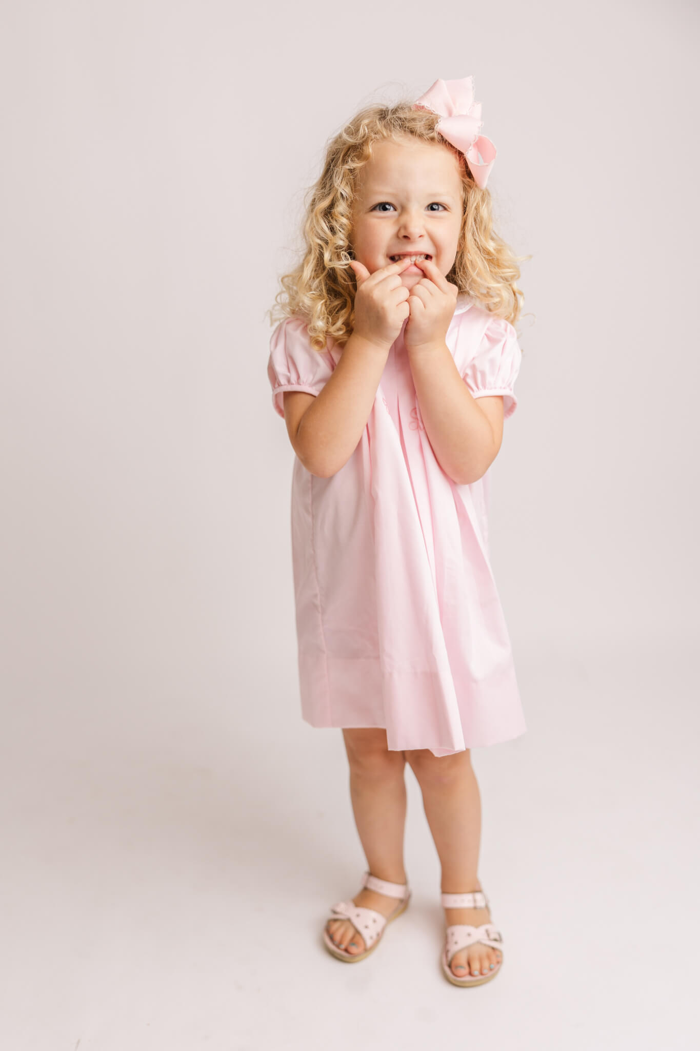 little girl in pink dress excited about being a big sister
