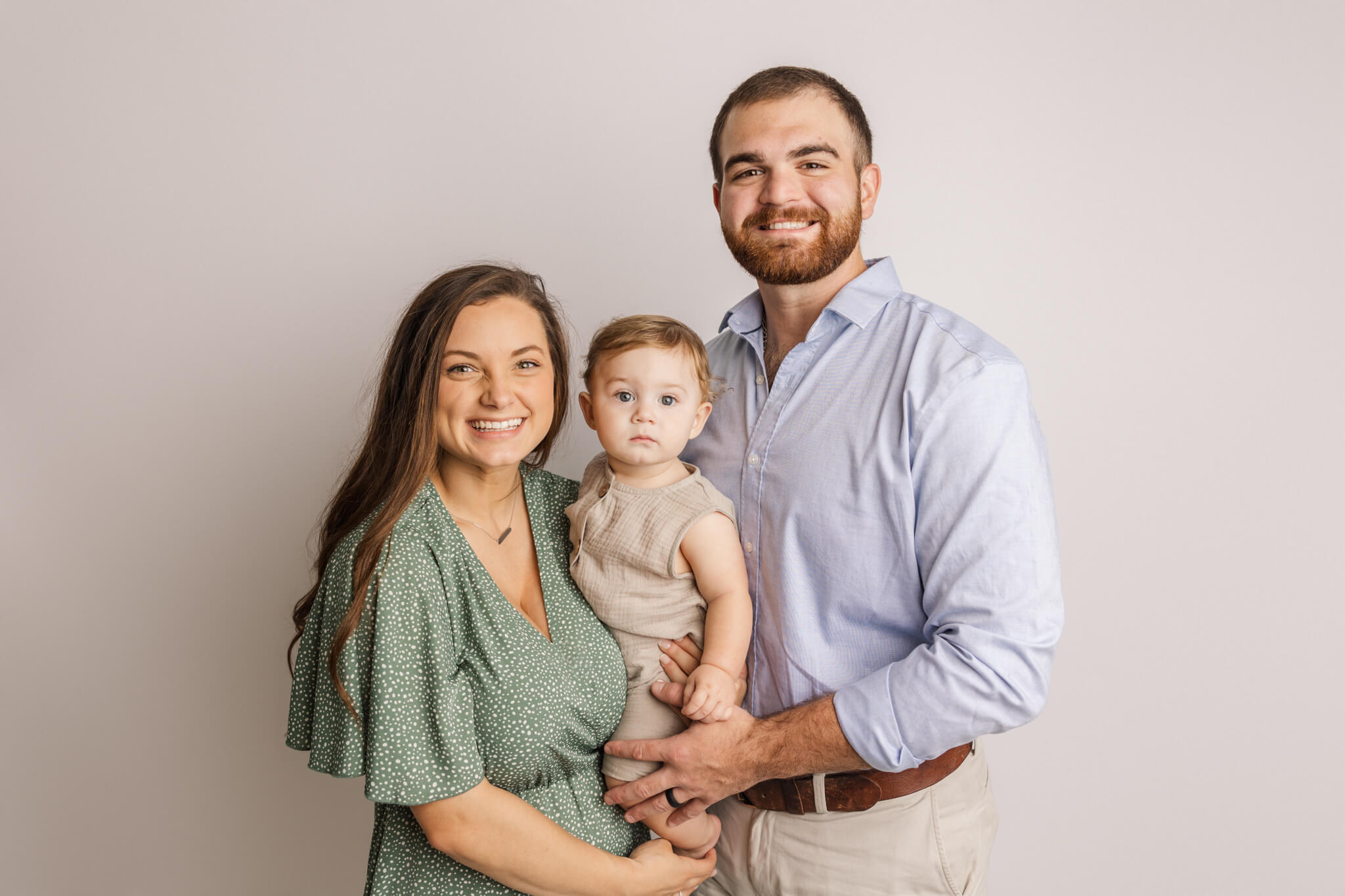 Family of three in the studio. mom is wearing a green dress from the client closet. little boy is also wearing a piece from the client closet.

Pitter Patter Aiken SC