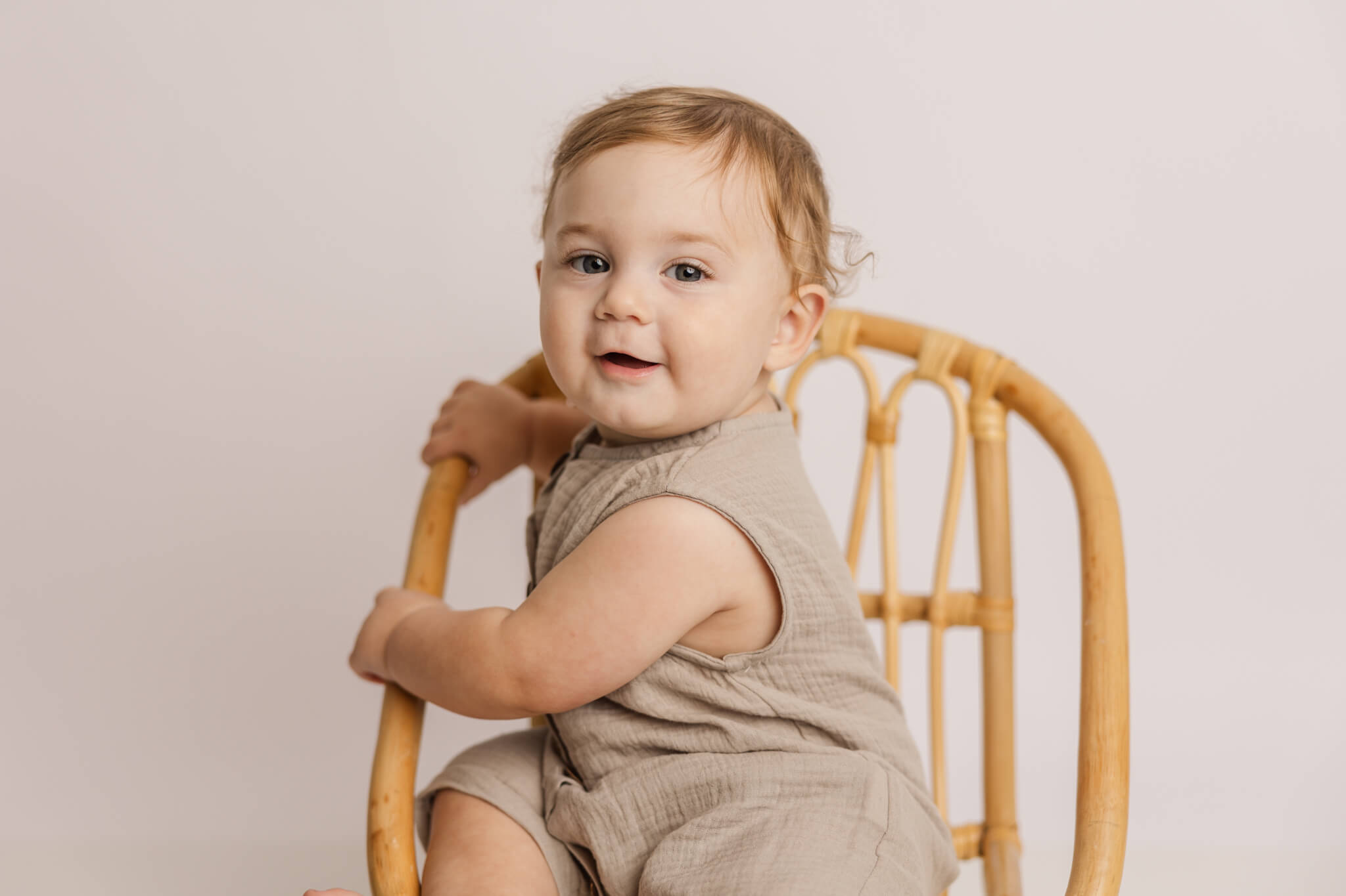 One year old boy sitting in a wooden chair during his one year celebration session with molly berry photography. Pitter Patter Aiken SC
