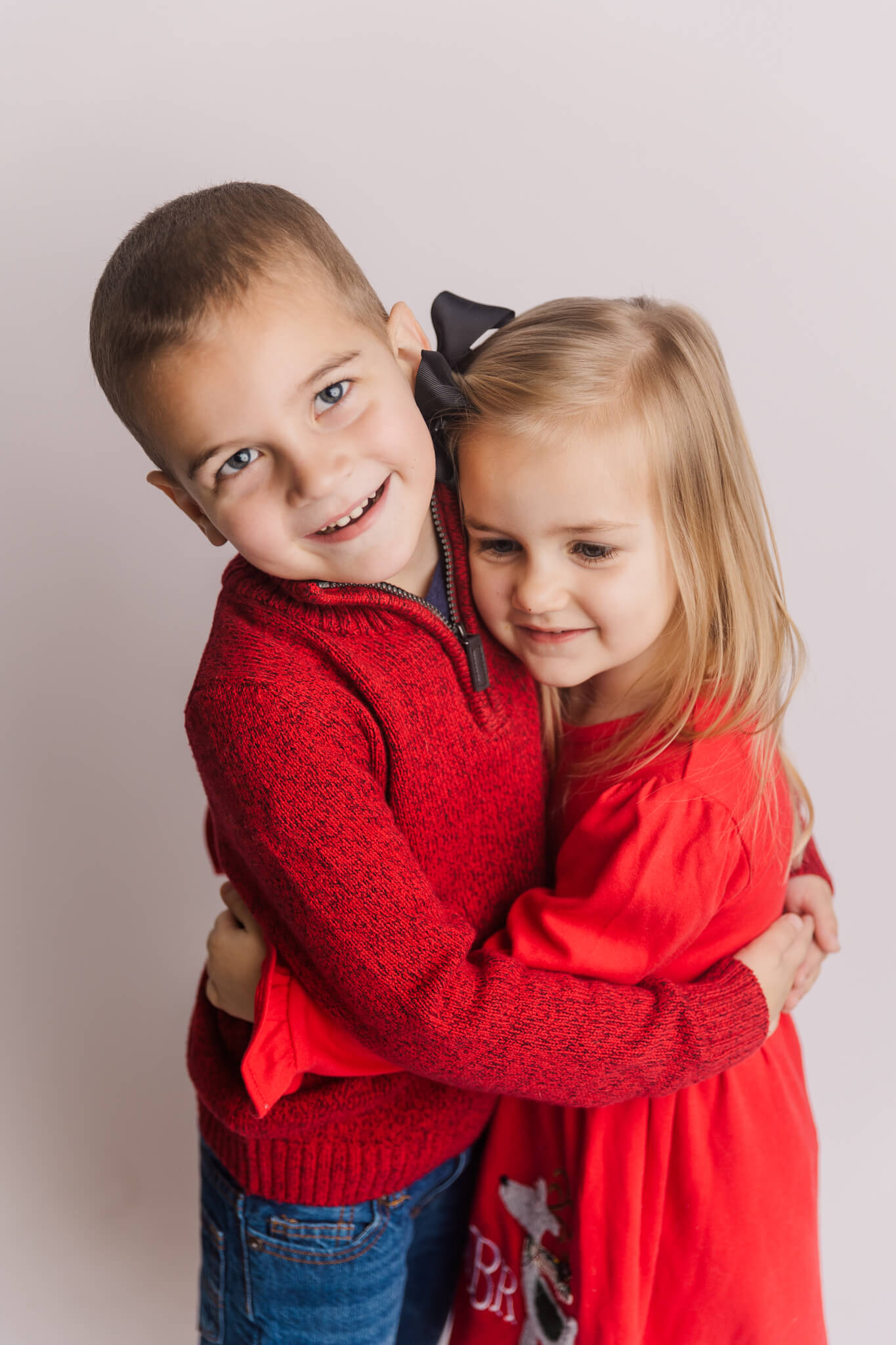 Brother and sister in red hugging The Ivy Boutique