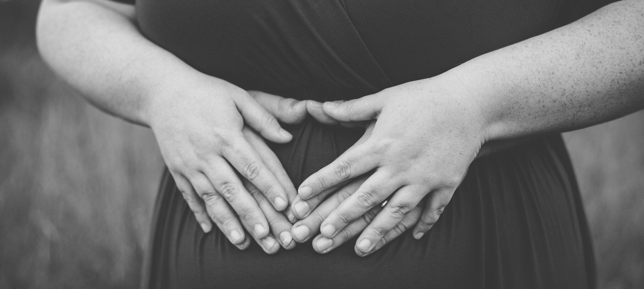 Mom and dads hands on pregnant belly