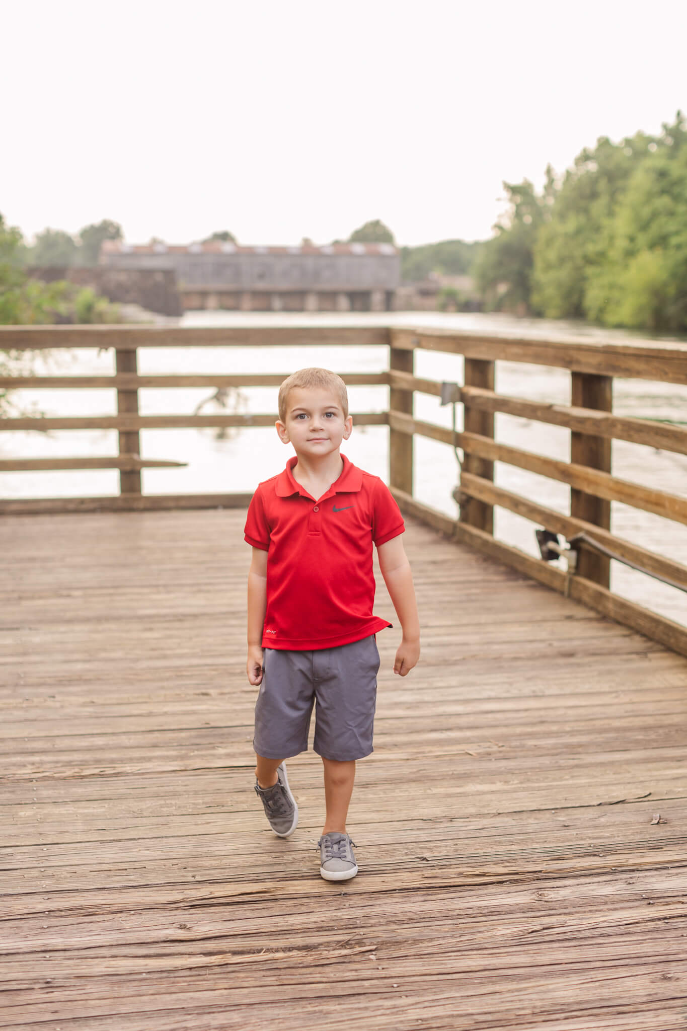 little boy in red polo walking along a boardwalk Southern Smiles Pediatric Dentistry