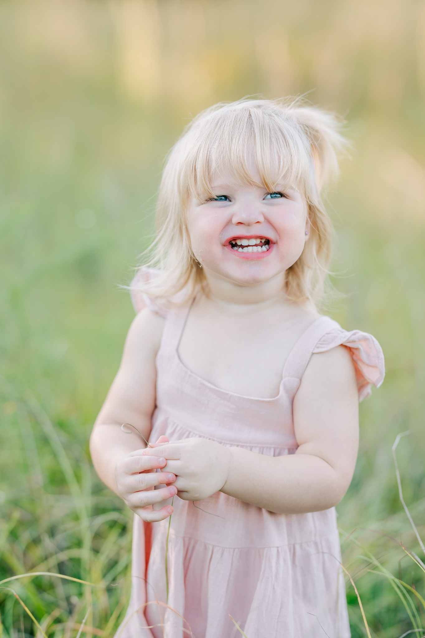 Two year old girl capturing a smile during her family photography session.