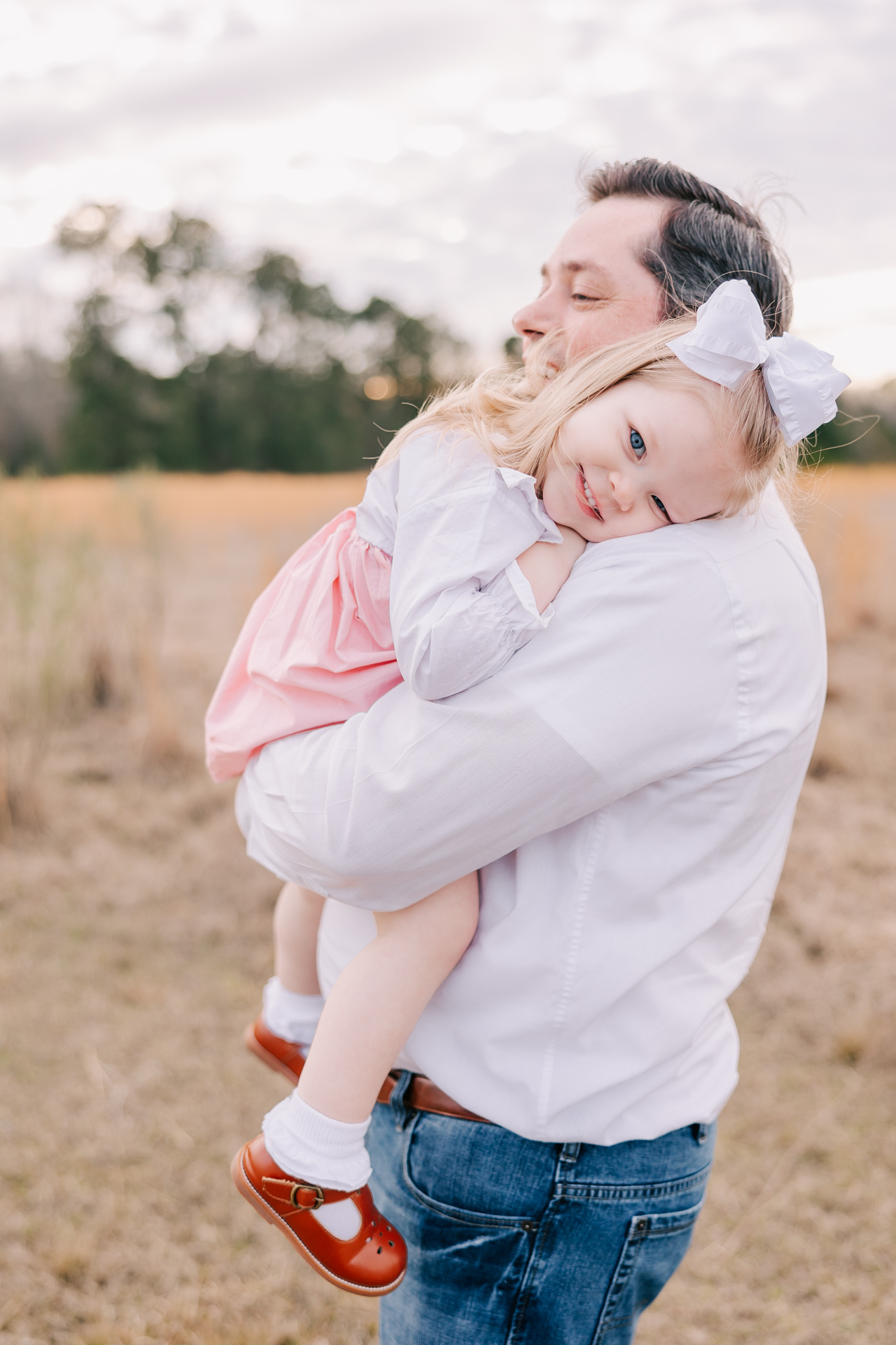 Dad and daughter sharing a moment during their family session in an open field in Grovetown GA