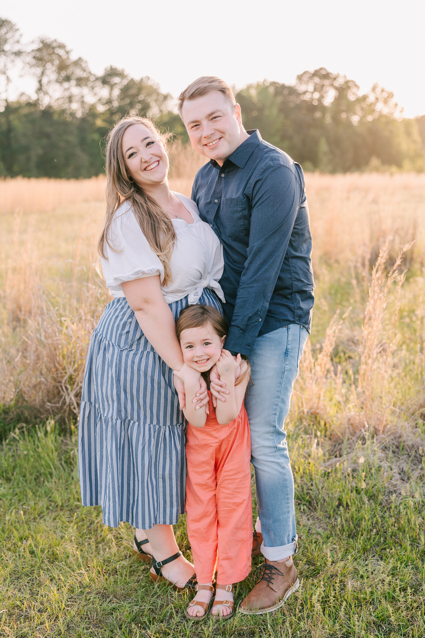 Family of three capturing a session in an open field in Grovetown GA