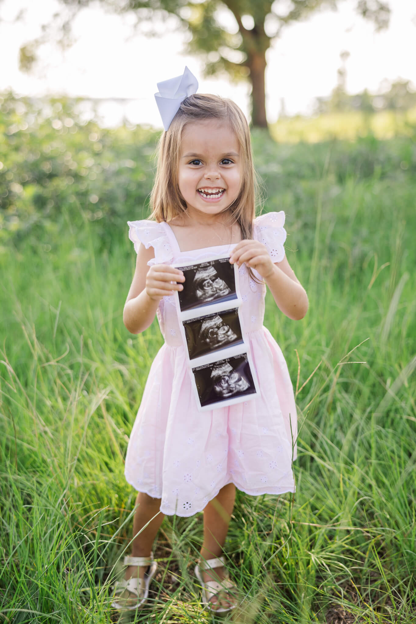 Little girl showing off sonogram picture of her future younger sibling
