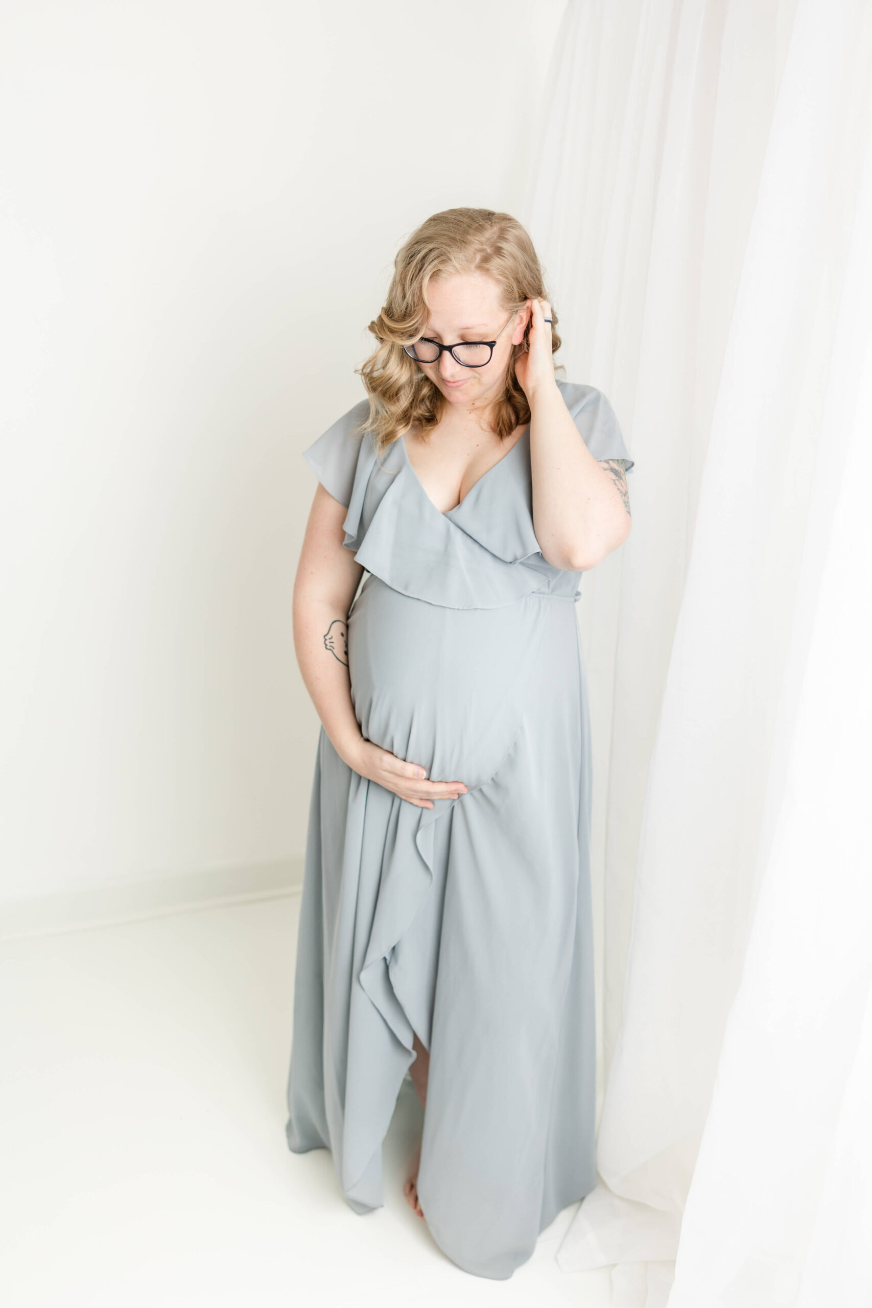 Soon-to-be mom in floor length blue gown.