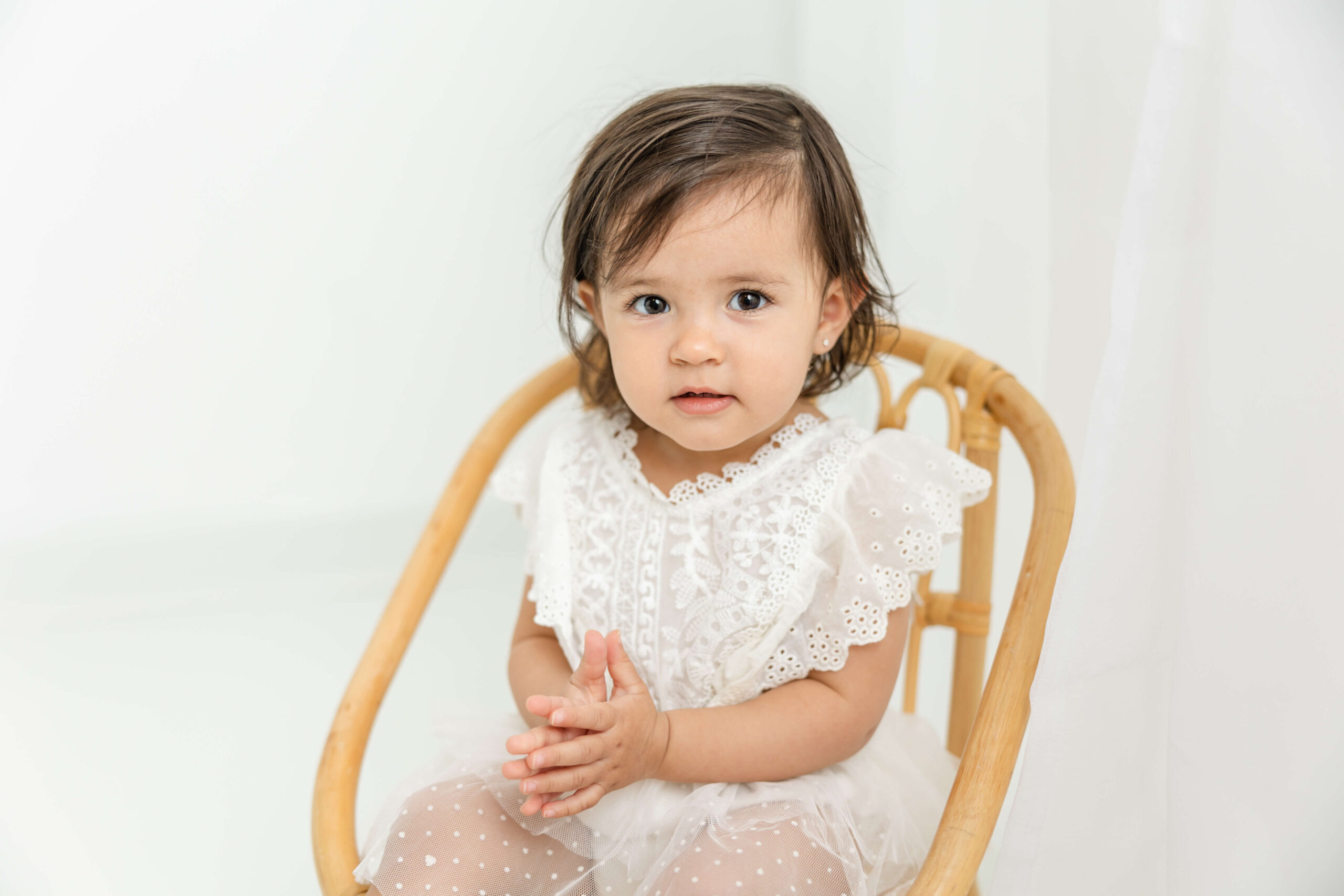 One year old baby girl clapping her hands during her augusta motherhood session.