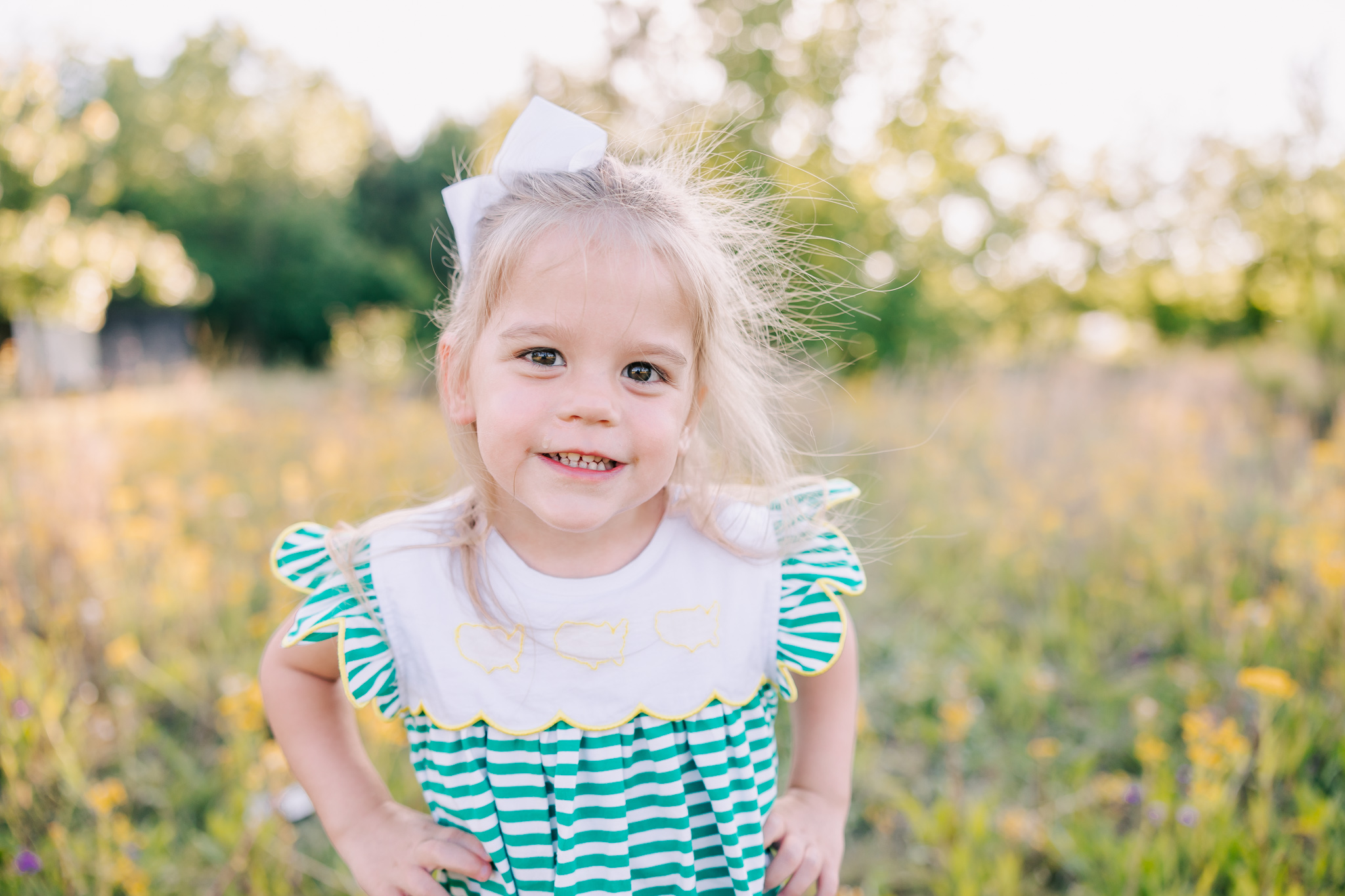 Three year old showing off a big smile during her milestone session in an open field in Evans, GA.