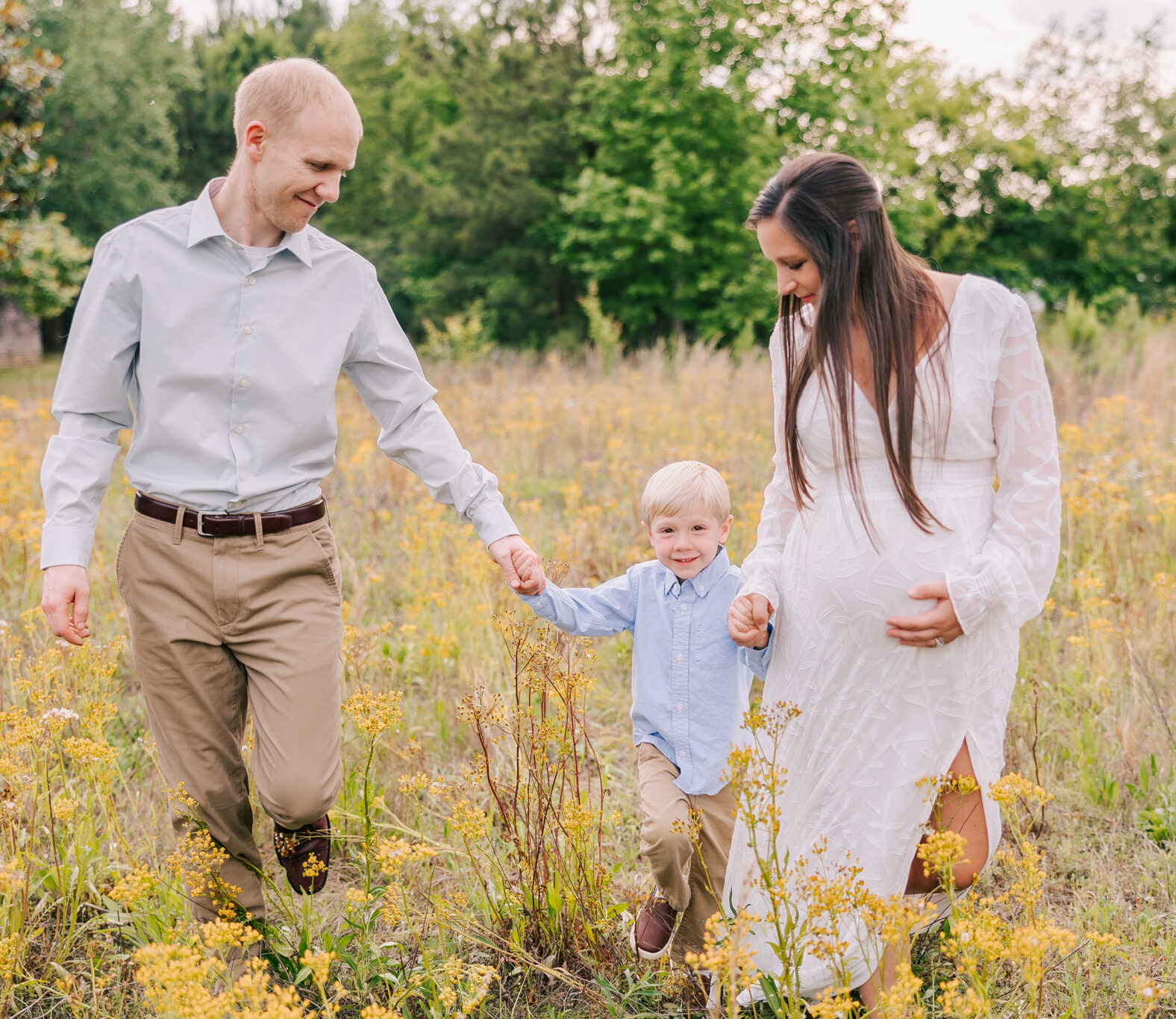 Family of three capturing smiles during their maternity session with molly berry photography.