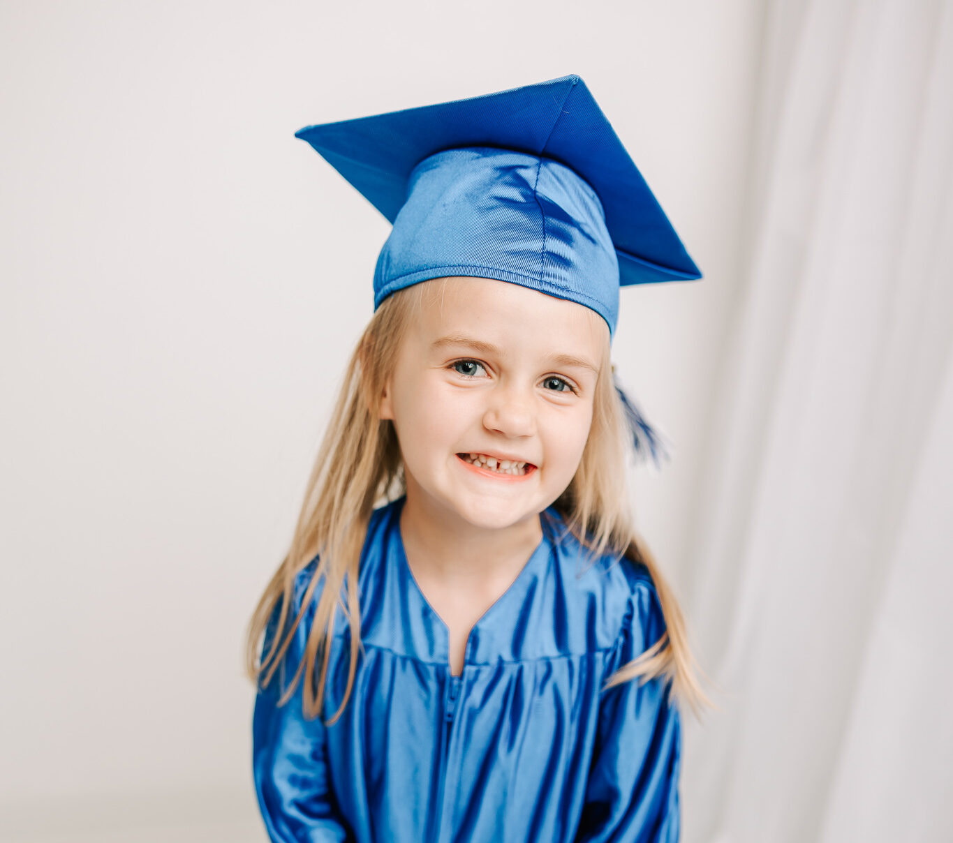 Sweet little girl dancing and twirling in her cap and gown in the augusta studio.