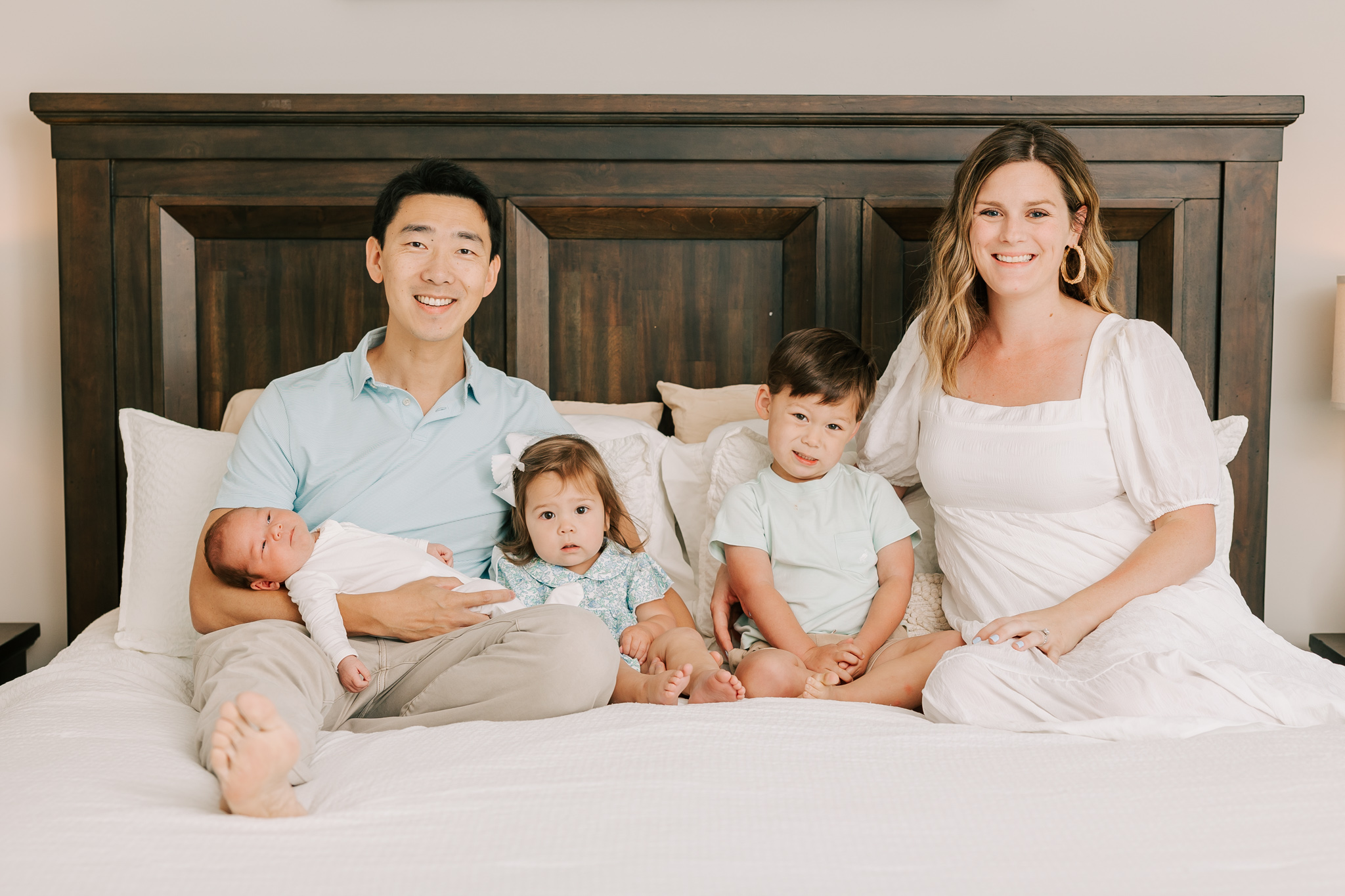 Family of five capturing a smile during their inhome newborn session in Columbia, SC. Mom used a lactation consultant Columbia SC to help her.