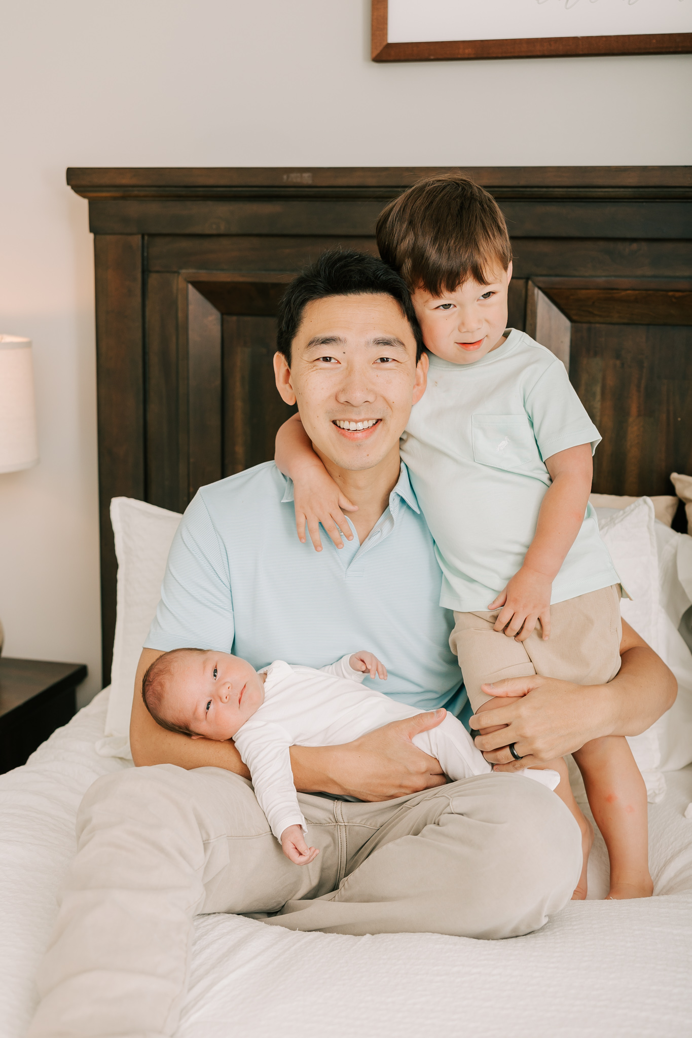 Dad and his two boys smile during their newborn session with molly berry.