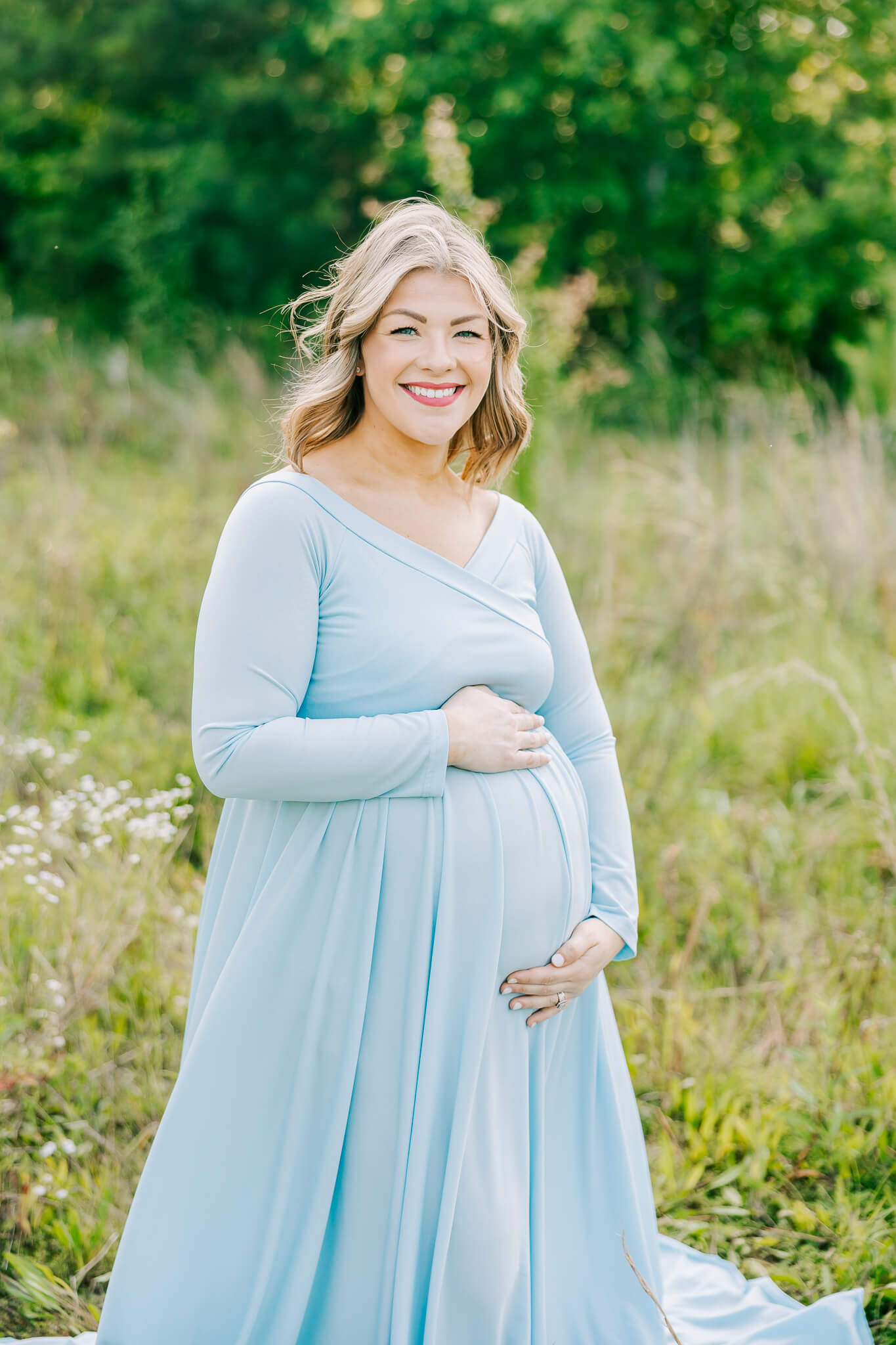 Pregnant mom capturing a smile during her atlanta maternity photography session.  Mom is wearing a light blue dress from my client closet.