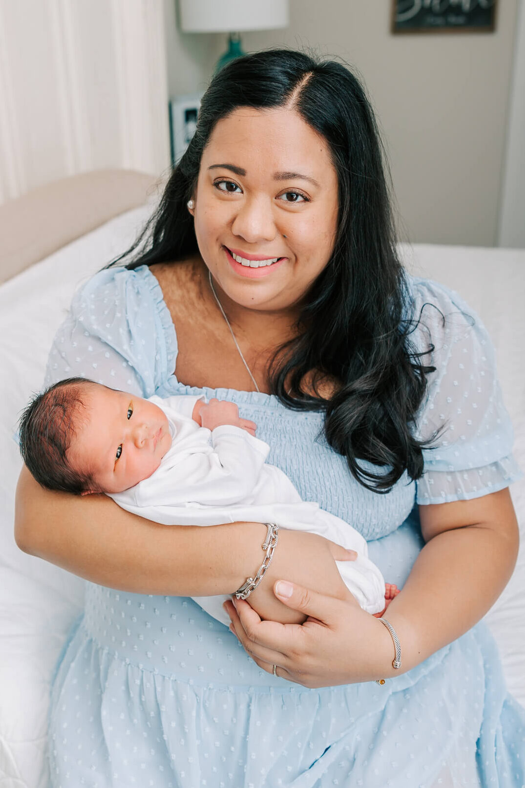 Mom and new baby boy share a smile during their in home newborn session with molly berry photography in atlanta.
