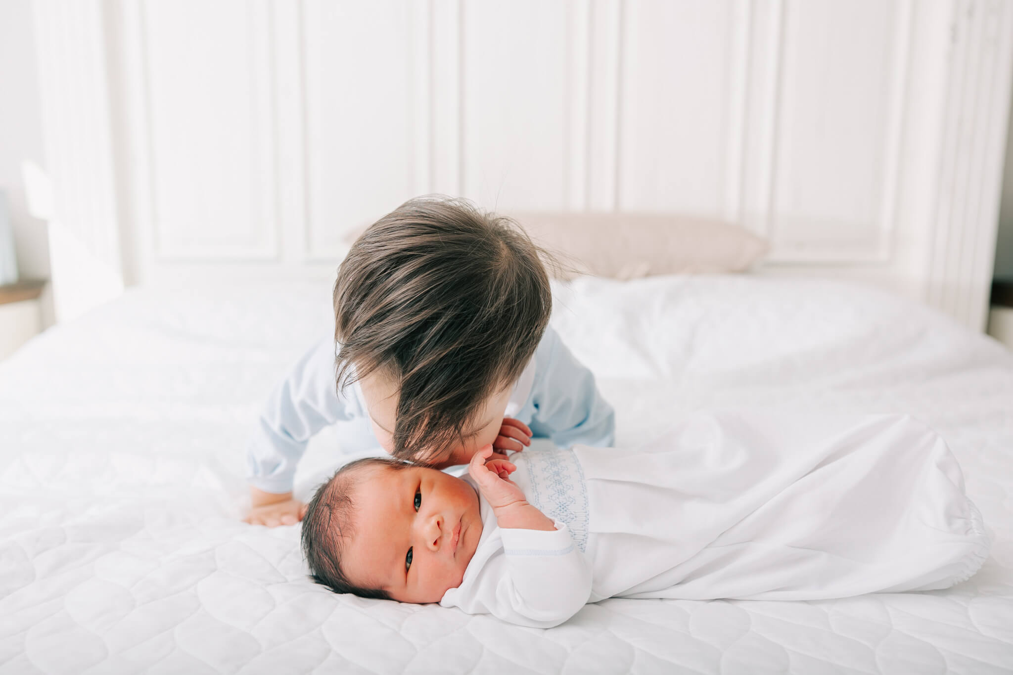 Big brother giving little brother a kiss during their in-home newborn session. Mom used Atlanta Lactation for lactation support with this newborn.