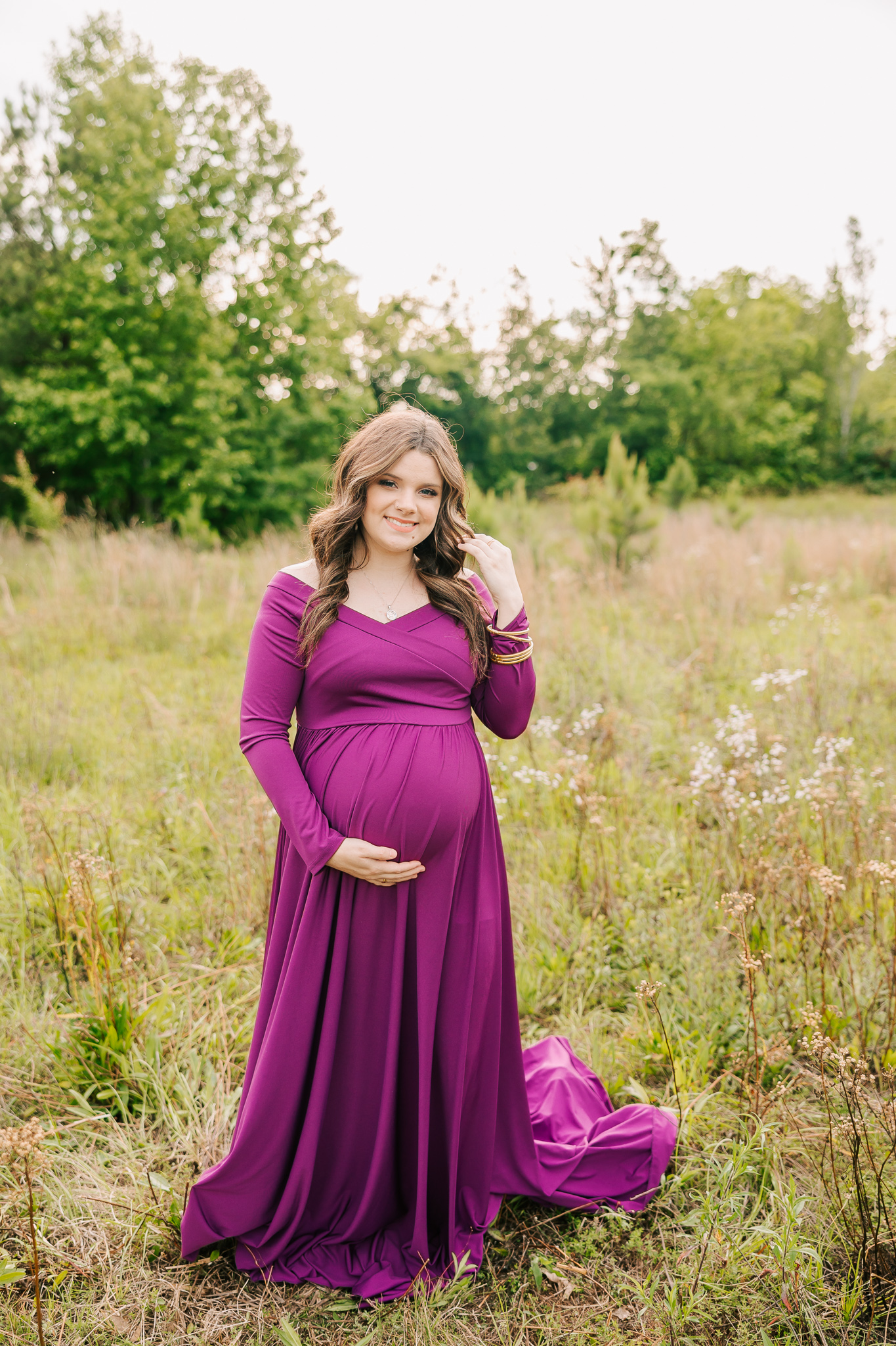 Pregnant mom walking through an open field for her maternity session with molly berry, your atlanta maternity photographer