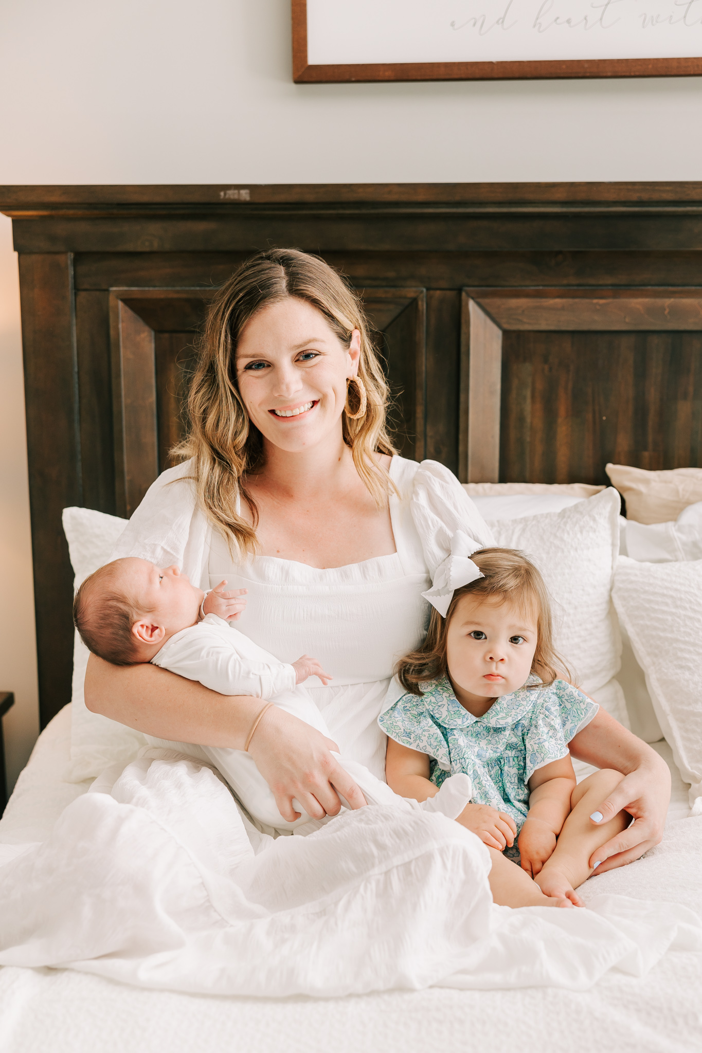 Mom and two of her little ones smile at the camera during their in-home newborn session. Mom used Postpartum Doula in Atlanta for her birth.