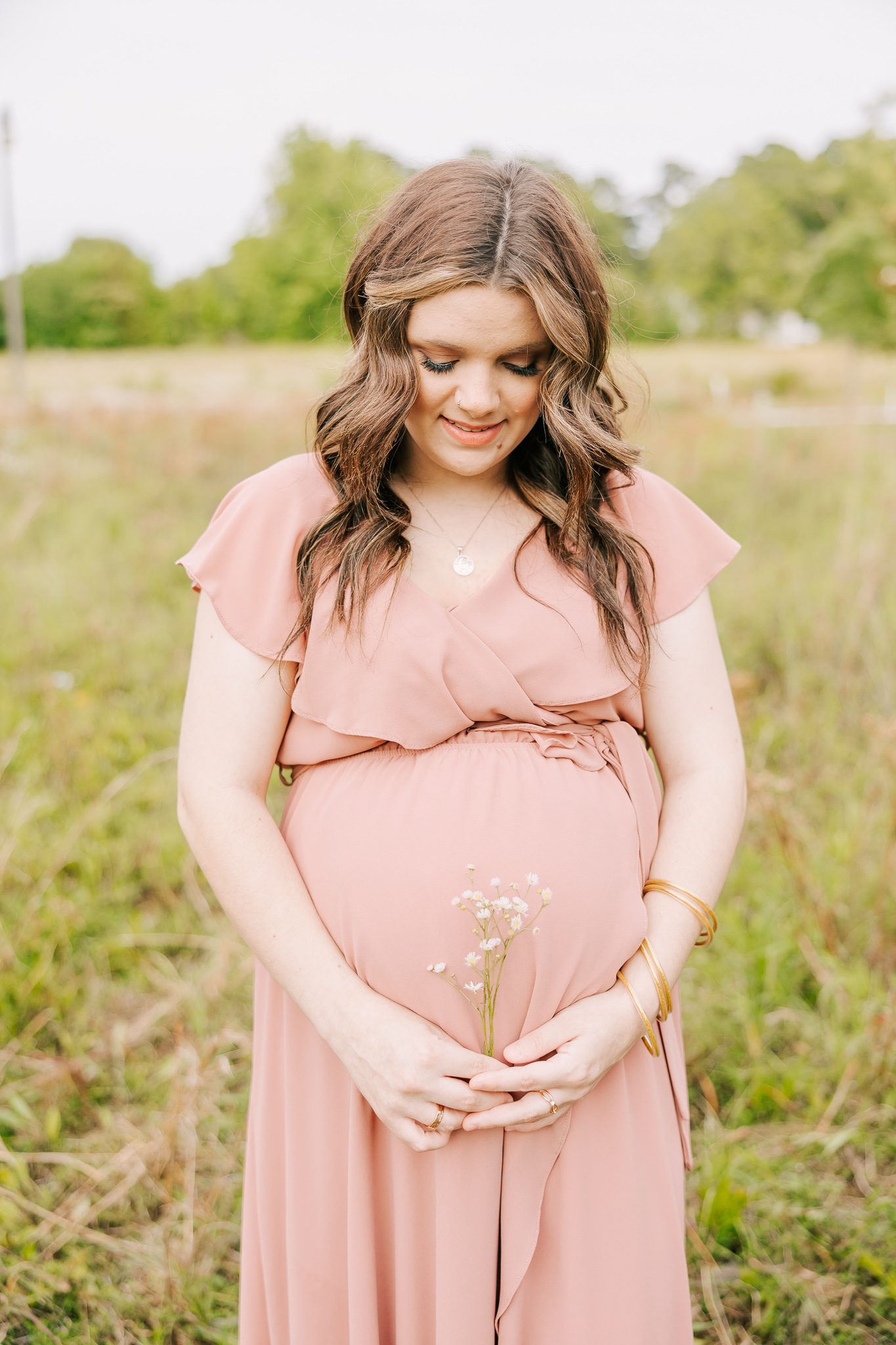 Expecting mom wearing a pink dress during her maternity session