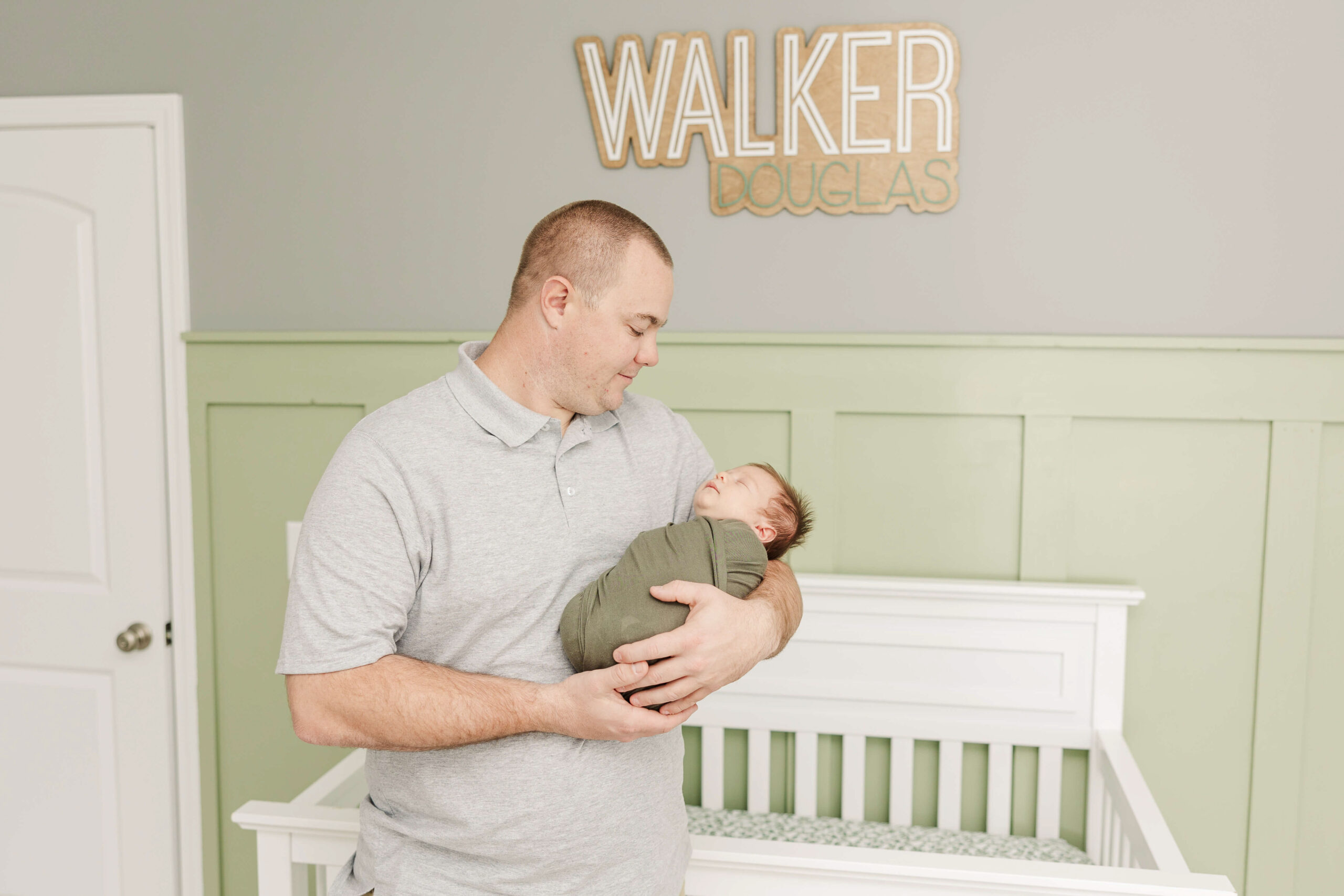 Dad holding his newborn baby boy during his aiken sc newborn session