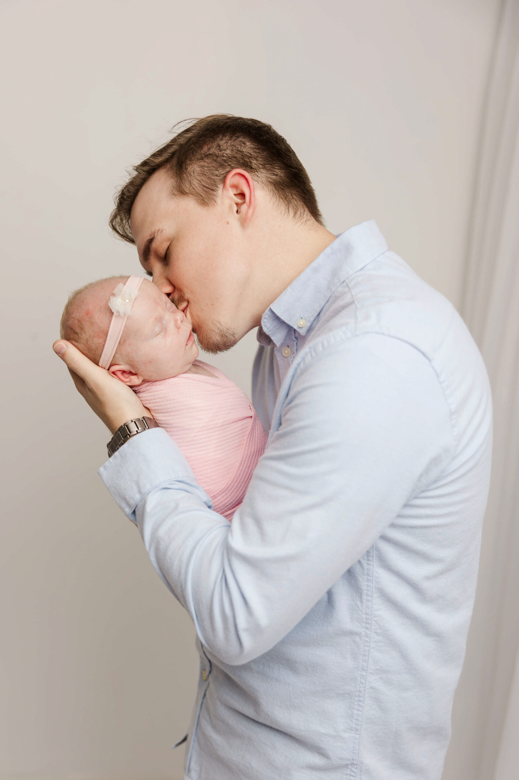 Dad kissing baby girl during newborn session with Molly Berry Photography