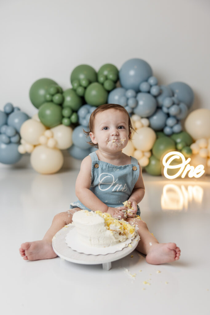 One year old eating cake in the studio of molly berry photography. cake smash photographer
