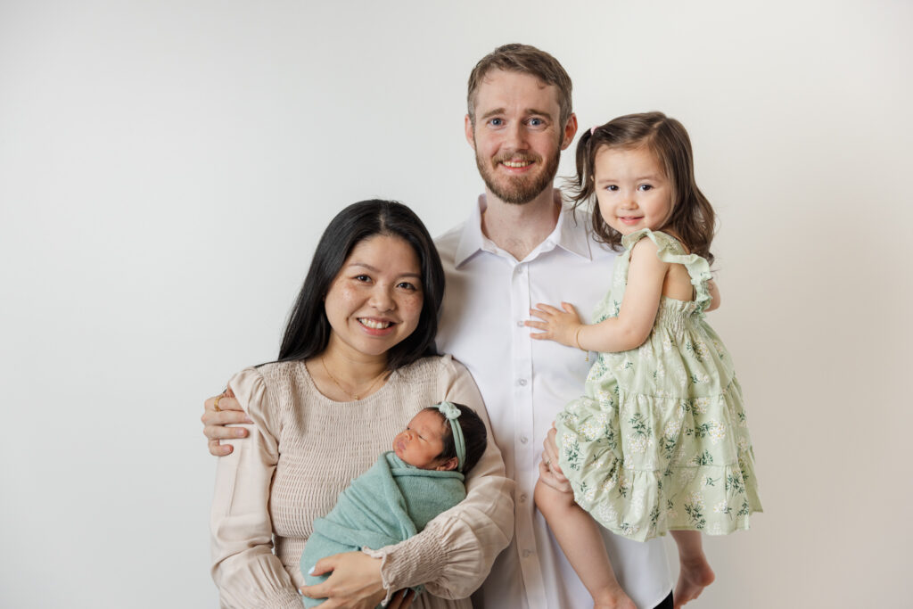 Mom dad and two girls during their studio newborn session